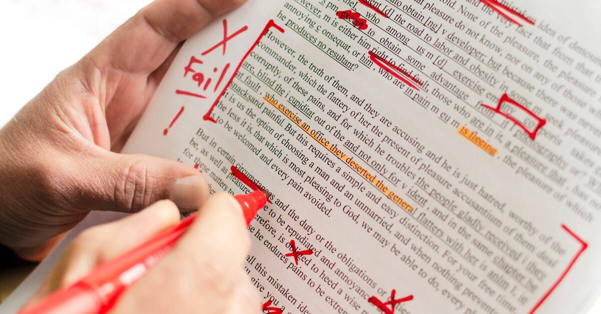 A printed page densely marked up in red pen, with the word Fail written in the margin beside a large X.